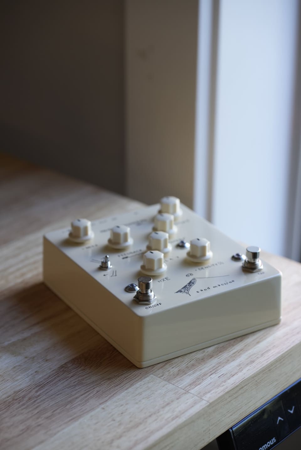 The Sand Machine seen from its jack edge, showing the input, stereo outputs, and power jack