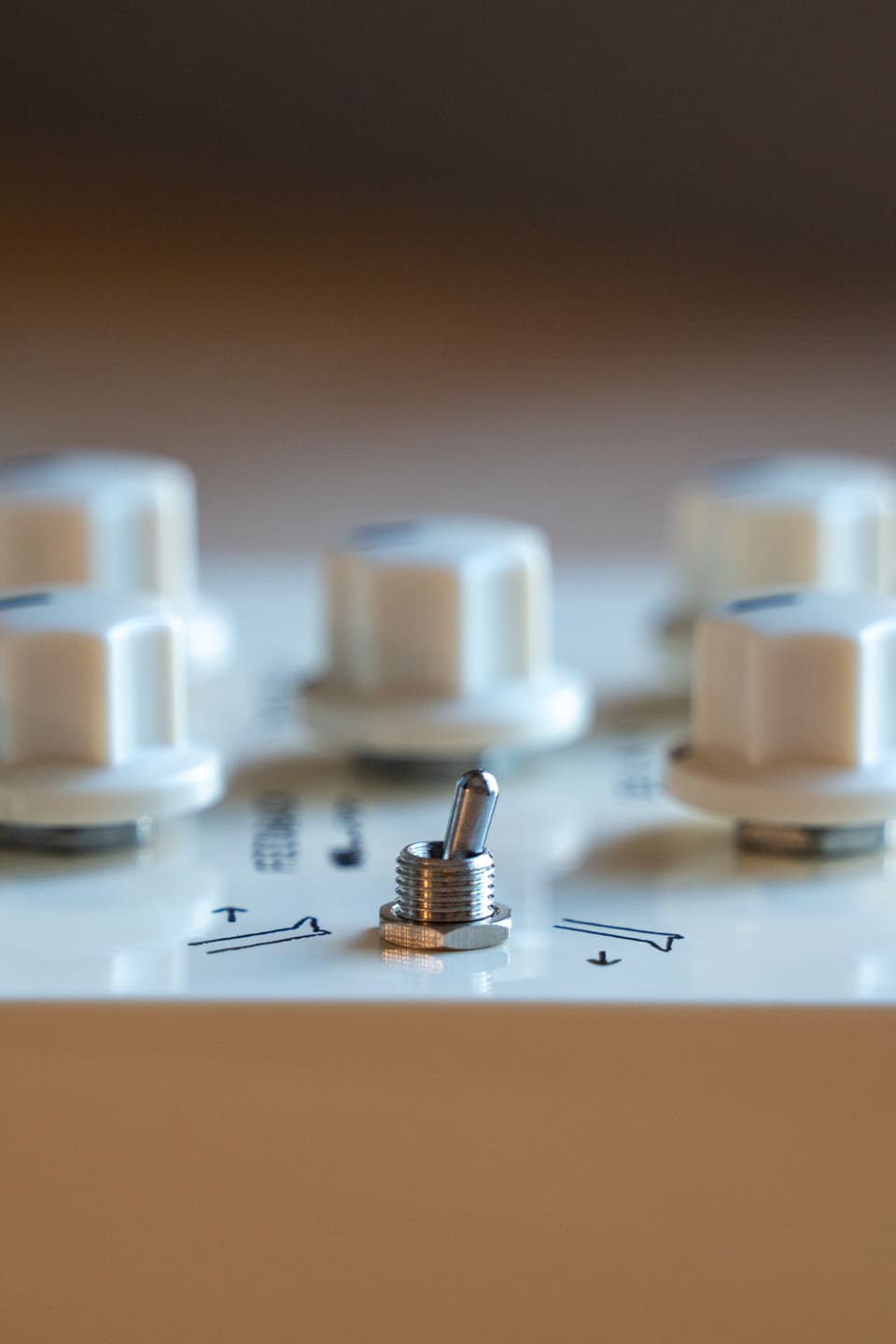 Macro shot of the Sand Machine's playback-direction toggle between its cream knobs