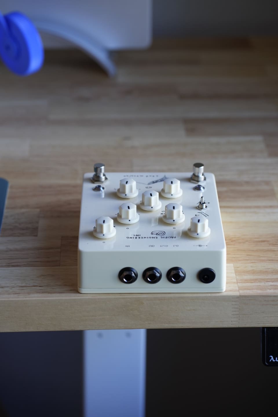The Sand Machine lying on a wooden desk in window light